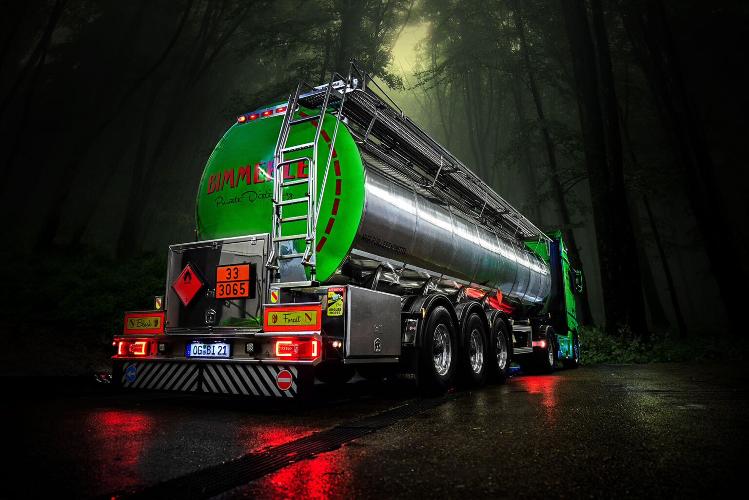 Ein großer grüner Tanklastwagen mit reflektierenden Elementen steht auf einer nassen Straße in einem dunklen Wald. Auf dem hinteren Teil des Lastwagens sind Gefahren- und Ladungshinweise angebracht. Das Fahrzeug trägt die Aufschrift 'BIMMERLE Private Distillery' und hat eine deutsche Nummernschild. Die Szene ist in einem stimmungsvollen, dämmrigen Licht gehalten.
